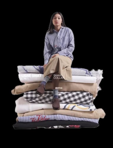 Personne assise sur une pile de vêtements pliés
