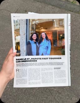 Le magazine Le Petit Bulletin tenu à la main, ouvert sur l'article consacré à Papote et la photo de ses deux fondatrices devant la vitrine